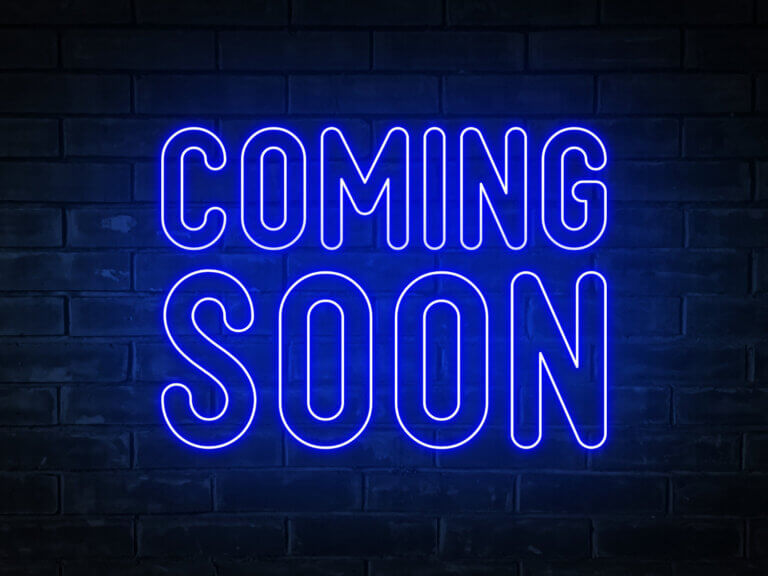 Coming soon blue neon light word on brick wall 1500