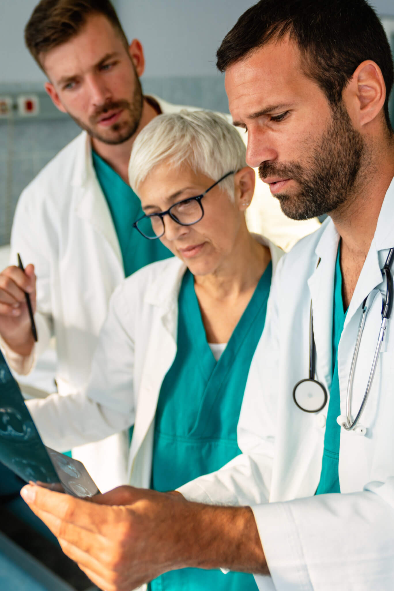 Group Of Doctors Checking X Rays In A Hospital.