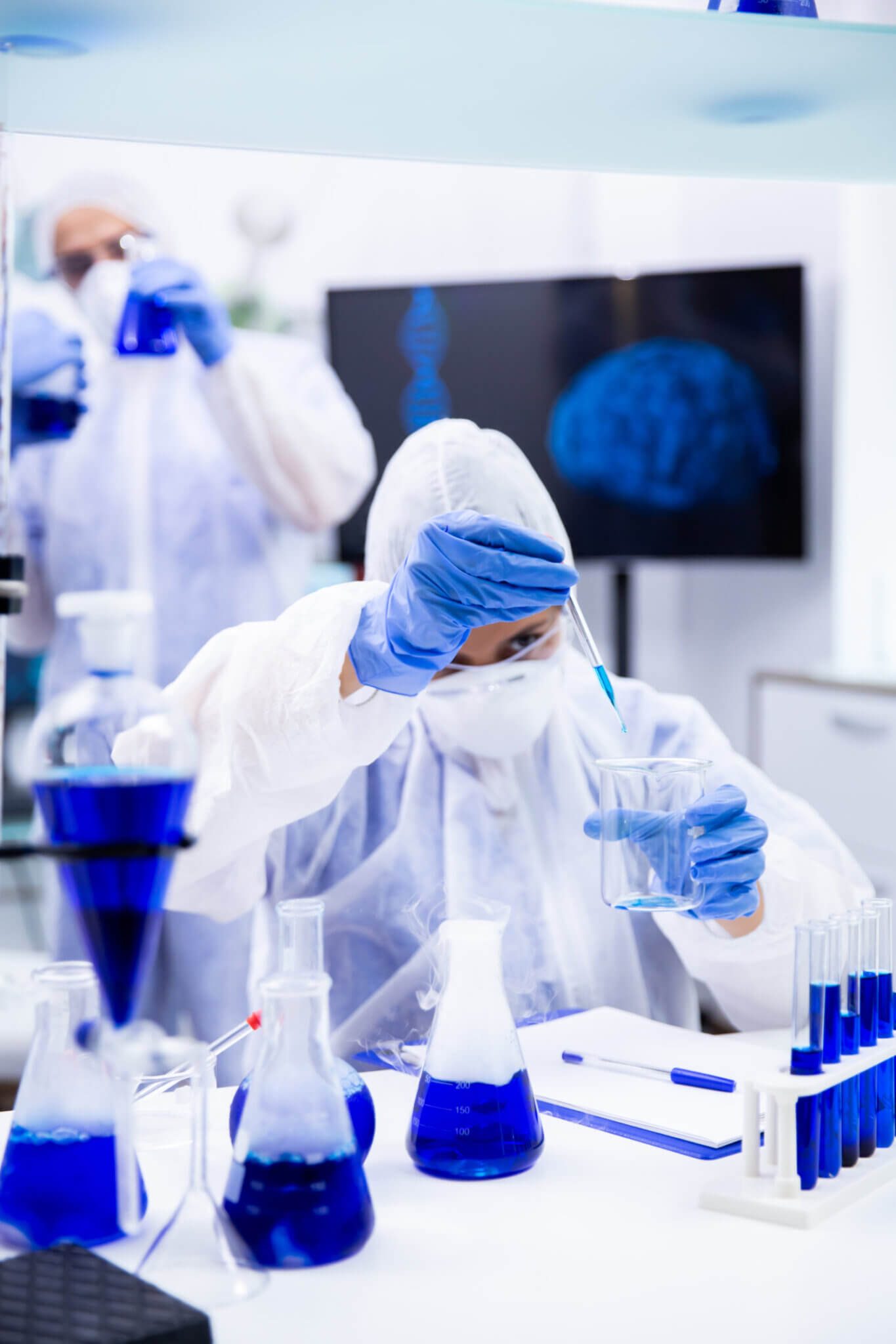 Chemist Holding A Pipette With A Blue Liquid Trying To Make An Experiment