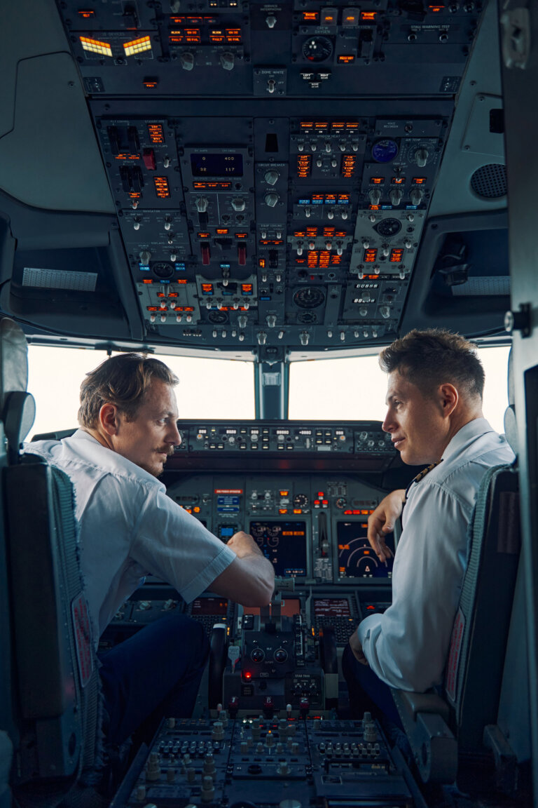 Two airmen dressed in uniforms sitting in the cockpit